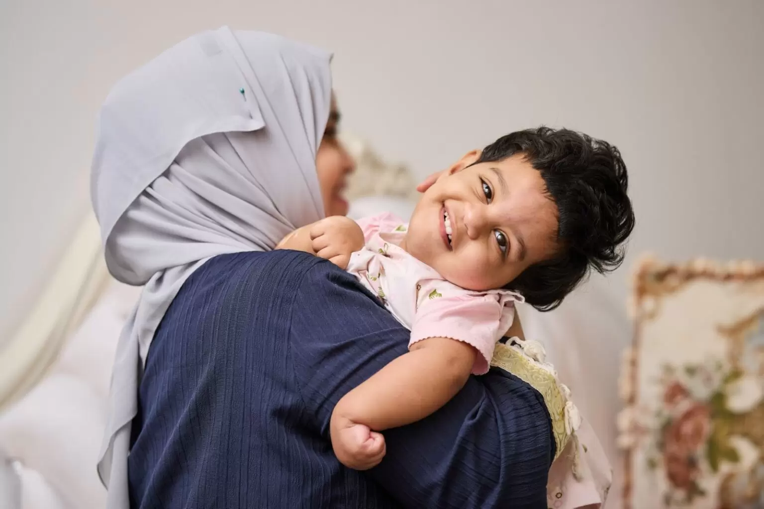 Grant recipient Huda happy in her mothers arms
